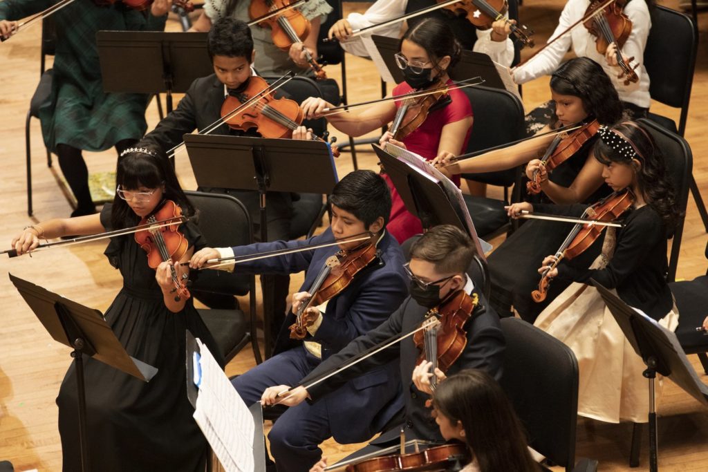 A group of Young Strings violinists perform during the 2022 end-of-year recital.